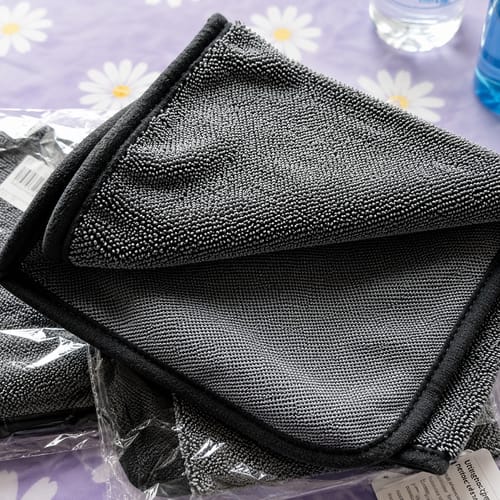 Deux lavettes microfibre Wove grises, l'une encore dans son emballage