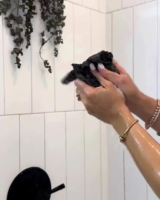 Cliente utilisant la serviette Wove sur son dos sous la douche